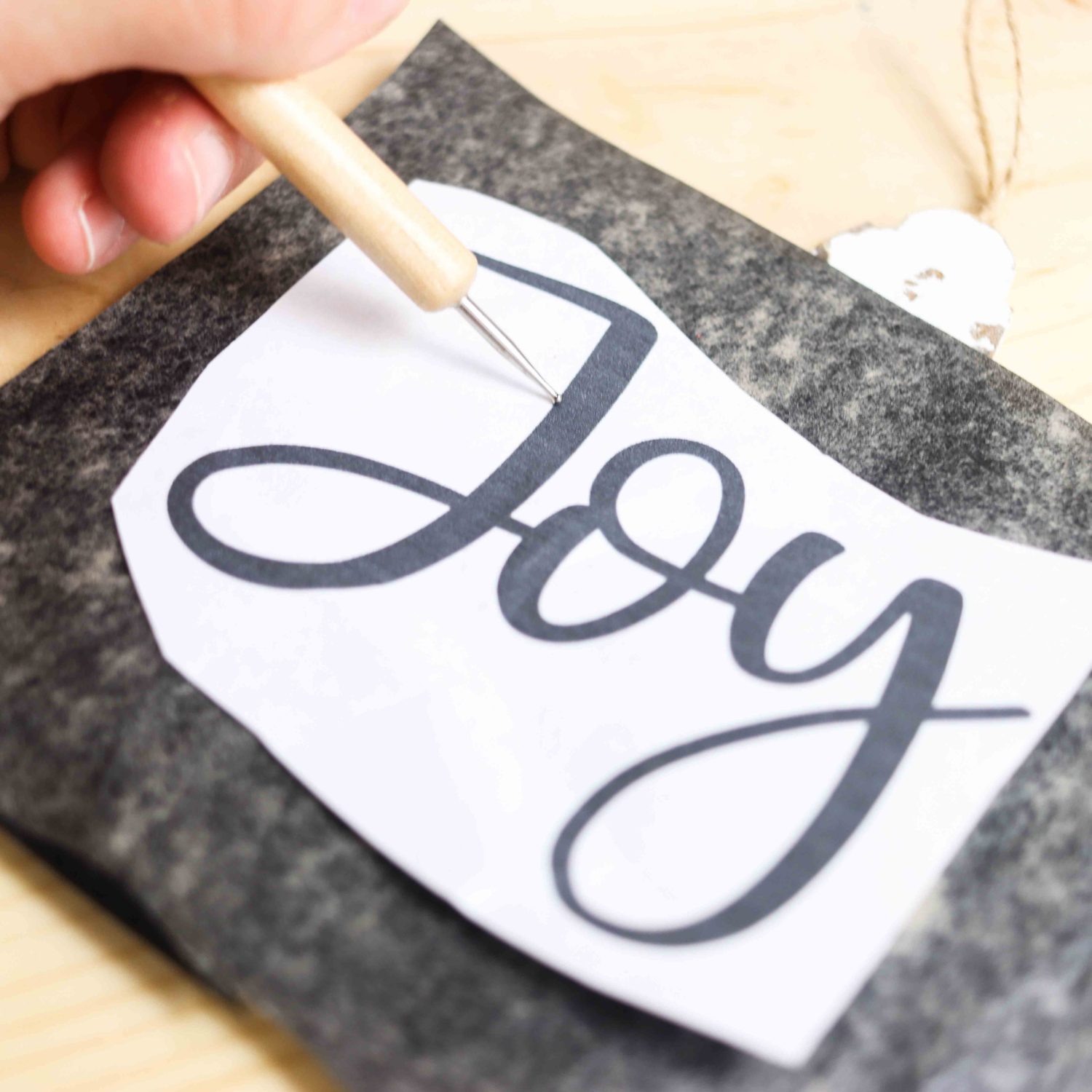 tracing a word with graphite paper on wooded slices