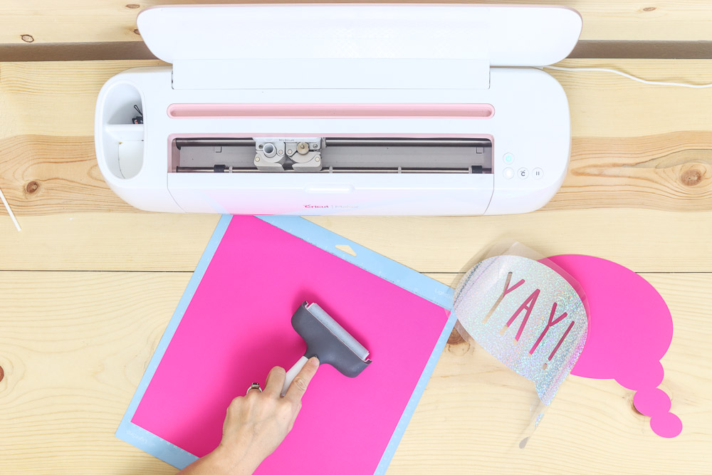 using the brayer to adhere light cardstock to the Cricut mat