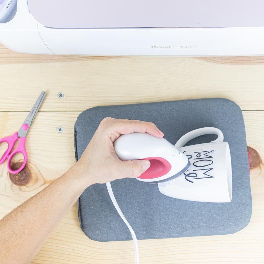 pressing iron-on on ceramic mug with HTV