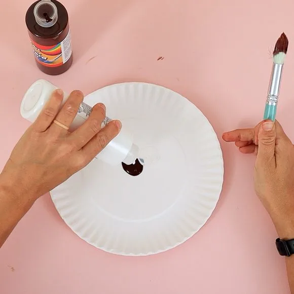 add brown paint to paper plate