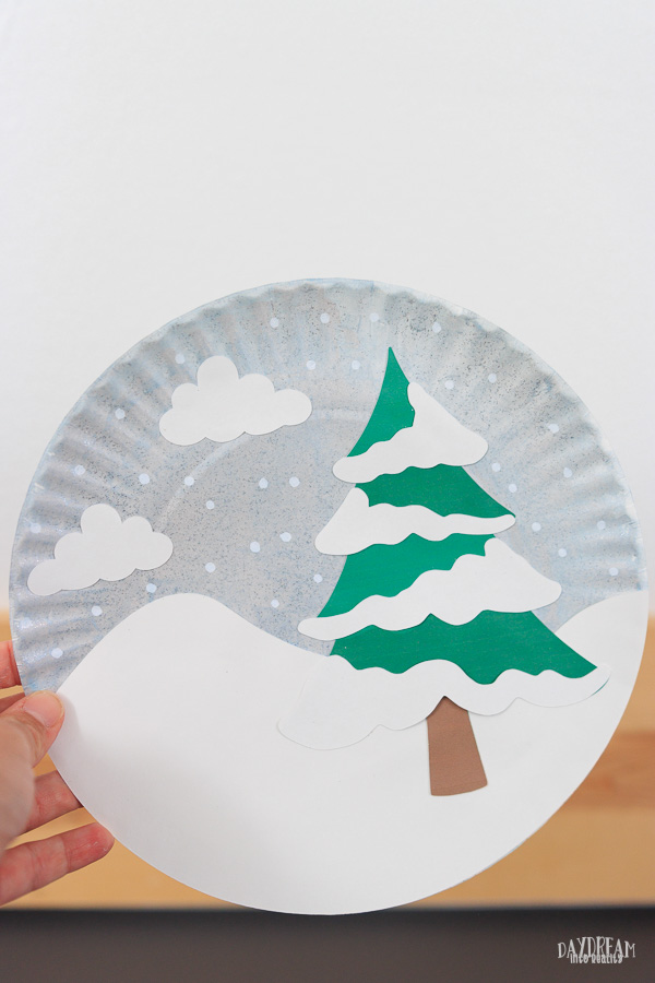 featured image paper plate winter tree scene. Evergreen, cloudy and snowy day.