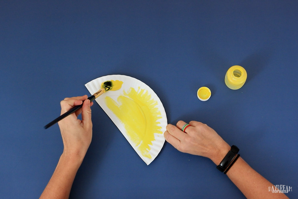 paint paper plate yellow to make the sun