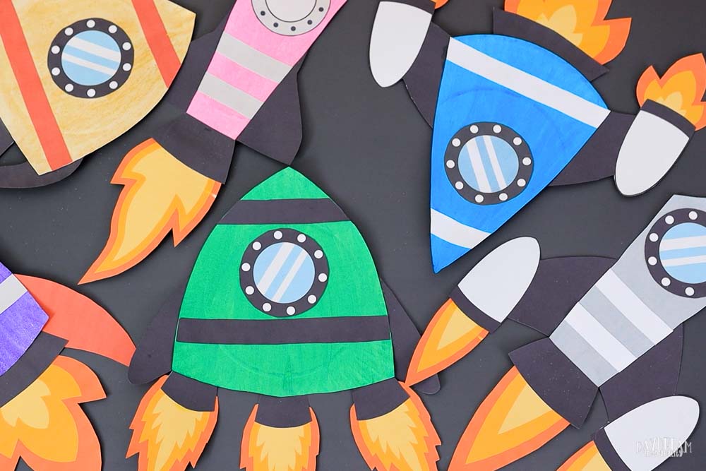 multiple rocket ships made out paper plates in different colors.